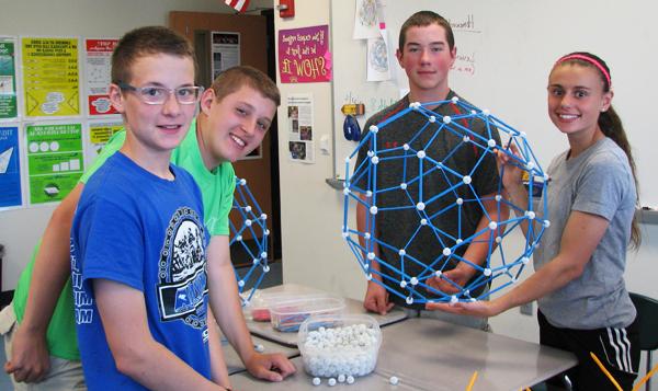 Four students show the center module of the structure.